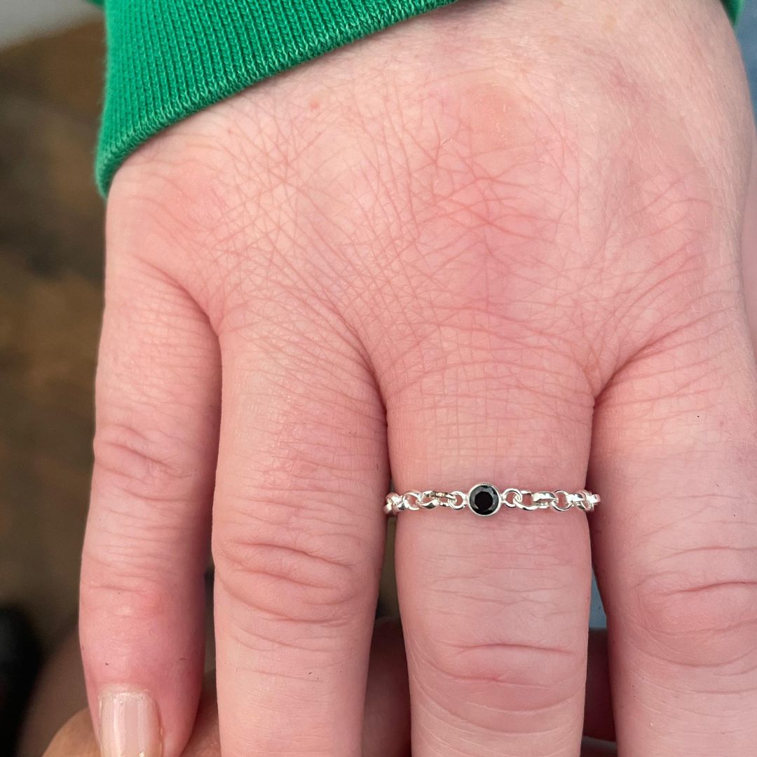 Close-up of a hand wearing a custom-fitted sterling silver permanent ring, highlighting the elegant and simple design.